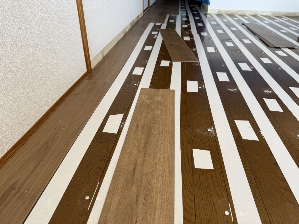 マンション床リフォーム施工中:棟梁が直接行う丁寧な床板の貼り込み作業