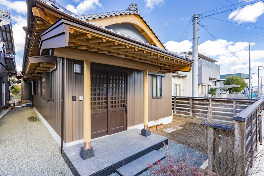 瓦屋根と木の破風のある玄関アプローチ